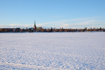Snow-covered landscape in Mora, Dalarna during winter in Sweden with a distant church tower