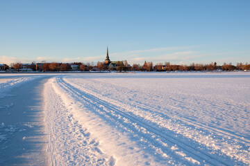 Winter landscape with snow-covered path and church in Mora, Dalarna, Sweden