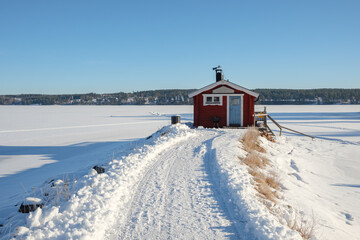 Winter tranquility in a remote red cottage by the frozen lake in Västanvik, Dalarna, Sweden