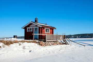 Winter cabin in Västanvik, Dalarna surrounded by snow and frozen lake