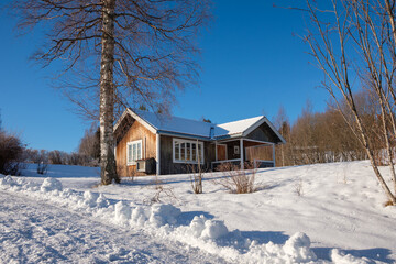 Winter landscape in Västanvik with a cozy cabin surrounded by snow