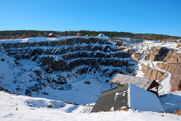 Winter landscape of the historic Falun Mine in Dalarna, Sweden under clear blue skies