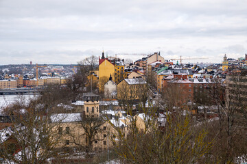 Snow-covered rooftops and winter landscape in Stockholm during a cloudy day