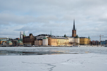 Winter landscape in Stockholm showcasing snow-covered buildings and icy waters