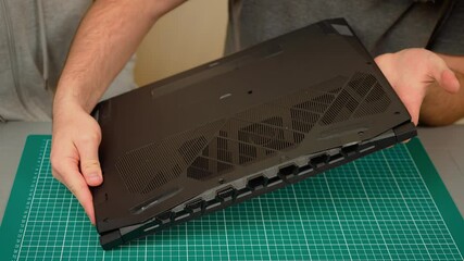 Father with son holding laptop bottom cover, discussing repair steps. Male with boy handling notebook panel, sharing repair knowledge. Guy with kid carrying computer case, explaining fixing process