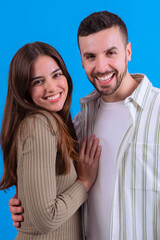 Obraz premium Happy couple posing together with smiles against a bright blue background.