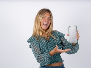 Beautiful teen girl wearing green fashion T-shirt with a mobile. presenting smartphone. Advertisement concept.