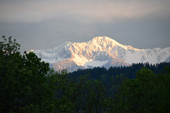 snowy mountains againt cloudy sky