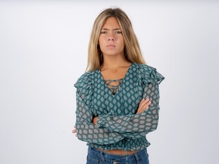 Gloomy dissatisfied MODEL looks with miserable expression at camera from under forehead, makes unhappy grimace