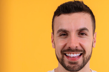 Close-up of a smiling man with a vibrant yellow background.Copy space