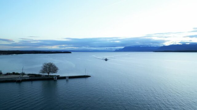 Orbit drone shot of boat sailing on Lake Geneva near Nyon in Canton of Vaud Switzerland