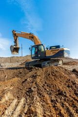 Obraz premium Powerful Excavator at Construction Site Under Blue Sky