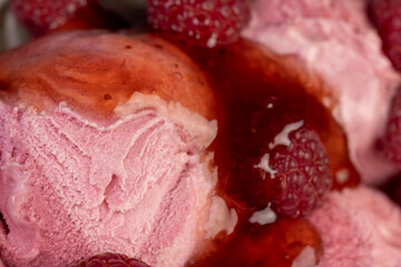 red raspberry ice cream in a glass bowl with raspberry jam