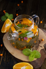 tea with orange and ripe sea buckthorn berries