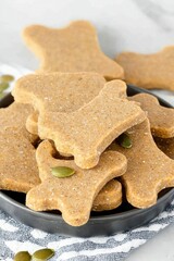 Homemade Dog Treats: A Stack of Bone-Shaped Biscuits with Pumpkin Seeds