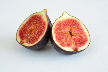 a fig that is cut on two halves isolated on white table 