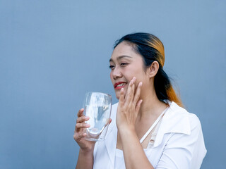 Asian woman feel sensitive teeth after drinking cold. Dental health problems