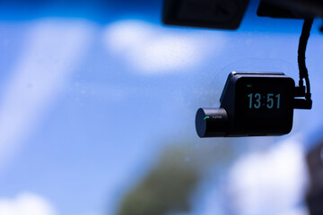 A small video camera records events. Attached to the windshield. Video monitoring concept for human driving safety