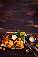 Fork with delicious falafel balls, sauce and vegetables on grunge background