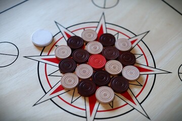 Carrom Pieces Arranged on a Wooden Star Pattern Board