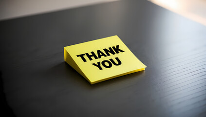 Yellow Thank You Card On Dark Wooden Table With Soft Lighting