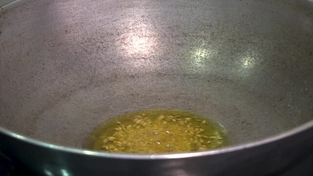 Adding Cumin in the oil. Cooking in the wok.