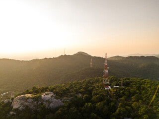 Obraz premium Telecommunications tower on the mountain while a beautiful sunset. Aerial view of amazing nature landscape