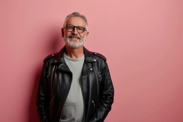 Fototapeta premium Portrait of a content man in his 60s sporting a classic leather jacket in front of solid pastel color wall