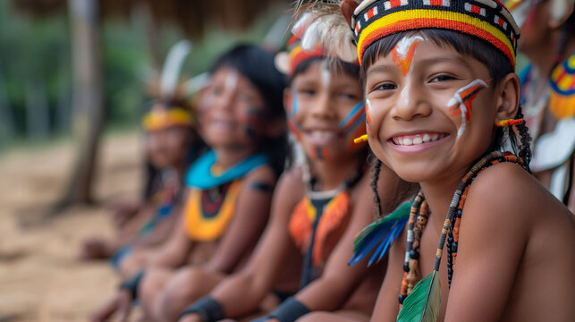 Indigenous children in traditional attire smiling joyously.
