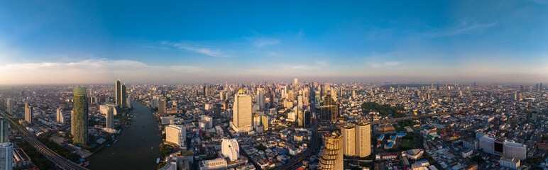 Aerial panorama of Bangkok city at amazing sunset. The first sun rays shine through the tall buildings at dawn. A large asian capital with skyscrapers and millions of inhabitants