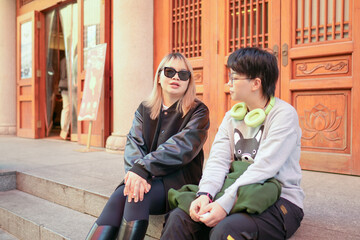 On a cold winter day in December 2024, two Chinese women in their 30s sit and talk in front of a historical building in Jing'an District, Shanghai, China.