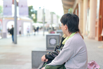 On a cold winter day in December 2024, two Chinese women in their 30s sit and talk in front of a historical building in Jing'an District, Shanghai, China.