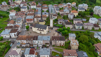 Fototapeta premium Mountain Serenity: Aerial View of a Scenic Village Amidst Clouds and Peaks