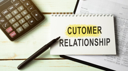 Customer Relationship text written on a notebook with pencils
