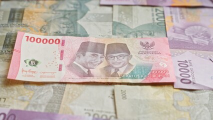 Obraz premium Indonesian rupiah banknotes displayed, including a prominent 100000 rupiah bill in the center, illustrating the currency from indonesia.