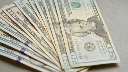 Closeup of various united states dollar banknotes fanned out on a concrete surface representing money and finance
