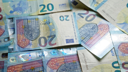 Obraz premium Close-up of scattered 20 euro banknotes showcasing european currency with intricate holograms and security features.