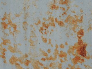 fragment of light metal surface with bright orange abstract rust streaks, texture of aged iron in gray-rusty tones with empty copy space