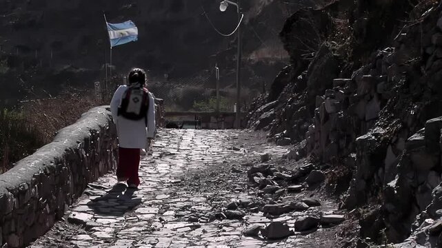Unrecognizable Primary School Girl Climbing Mountain Trail to School in San Isidro de Iruya, Argentina 