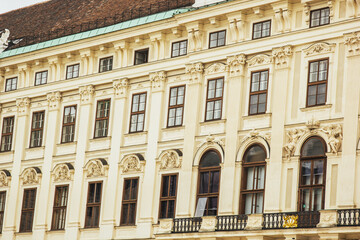 Obraz premium Vienna, Austria - May 12, 2019: Windows of beautiful palace with sculptures over the, closeup photo. Ancient architecture of residential buildings.