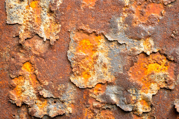 Naklejka premium Close-up of weathered rusty metal surface with peeling paint texture