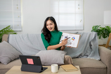 Asian woman presenting business report using video call at home