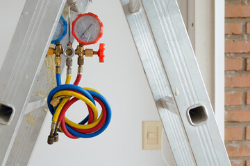 air conditioning gas meter hanging from an aluminum ladder, close-up