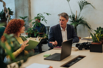 Managers discussing business strategy in modern green office