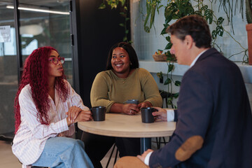 Diverse business team enjoying coffee break in modern office