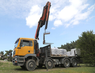 a truck with a manipulator transports construction cargo
