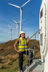 latin Female engineer holding walkie-talkie at wind turbine power plant