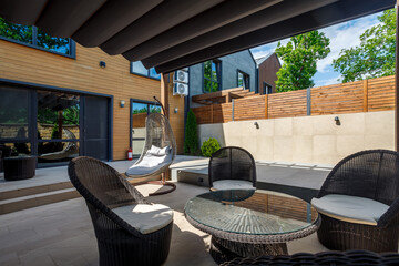 Backyard outdoor bbq zone with pergola, fireplace and hanging chair. Summer party place