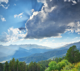 A view on mountain range and sunlight rays through clouds.
