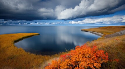 Obraz premium Tranquil waters reflect a dramatic sky, framed by vibrant autumn foliage along the shore, Ideal for nature-themed projects, travel brochures, or landscape art,